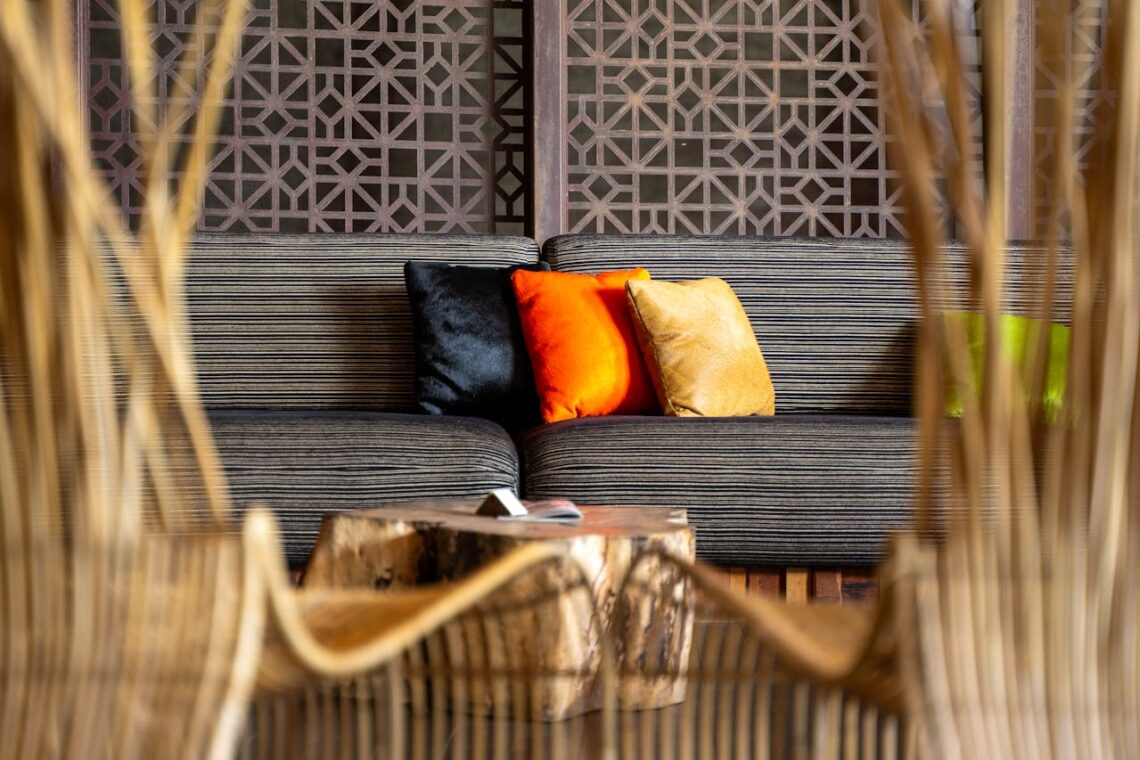 Contemporary living room featuring vibrant cushions on a striped sofa, with elegant wooden decor.
