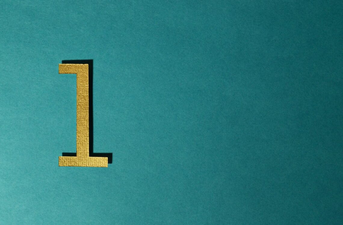 A gold number one on a teal background with ample copy space.